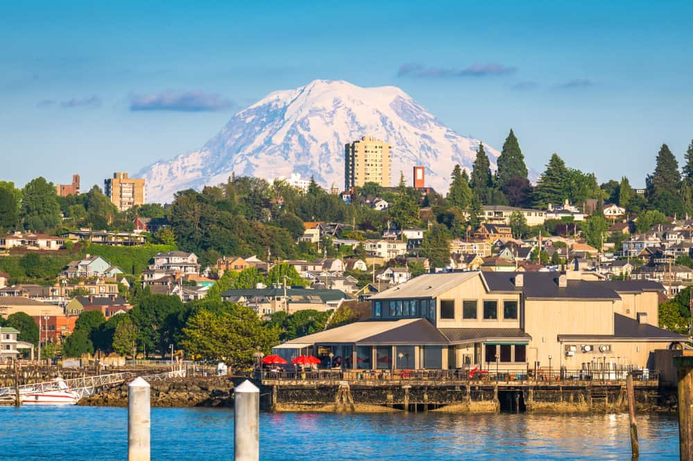 View of Tacoma’s waterfront buildings and hillside homes with snow-capped Mount Rainier rising in the distance.