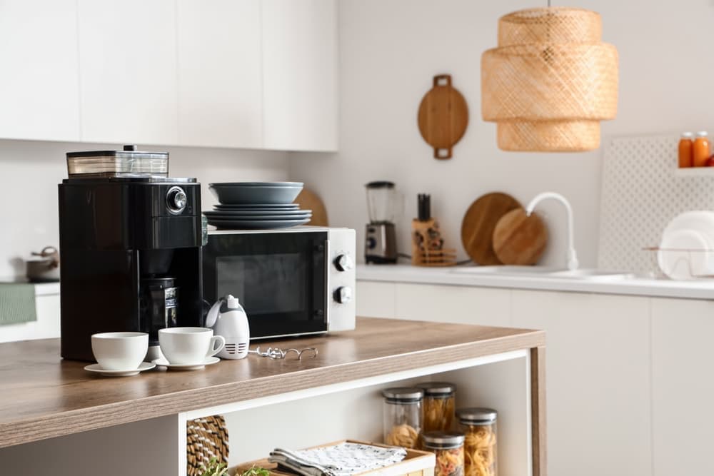 A kitchen with a lot of appliances on the counters.