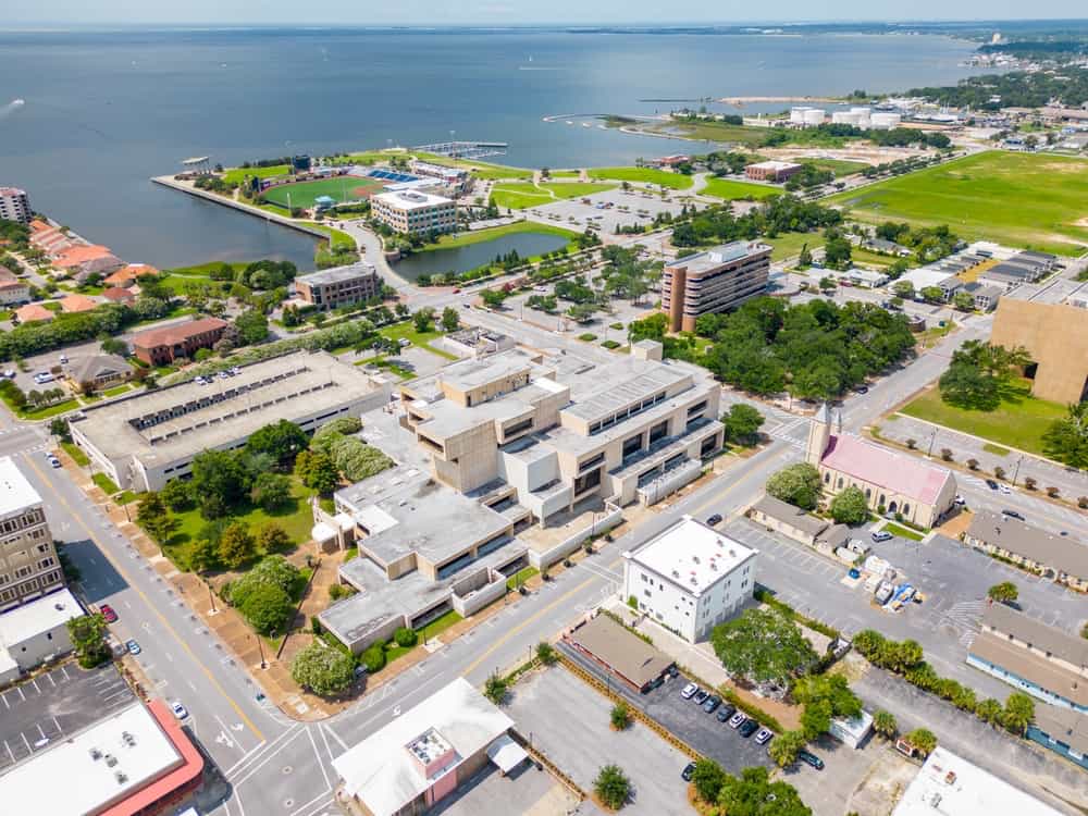 Sky view looking down on Pensacola buildings with the ocean in the background during daytime