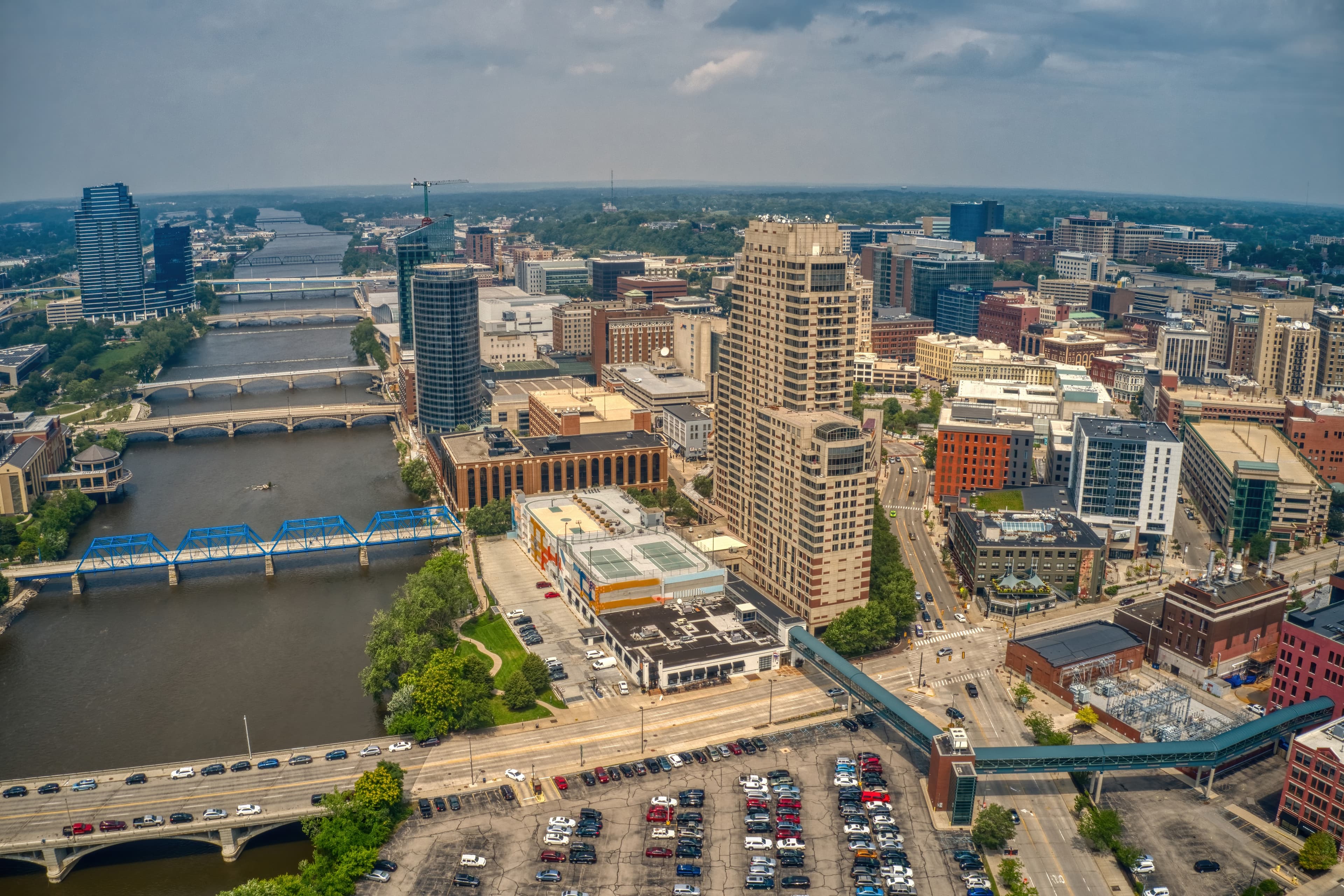Aerial view of downtown Grand Rapids, showing the Grand River, multiple bridges, and city buildings.