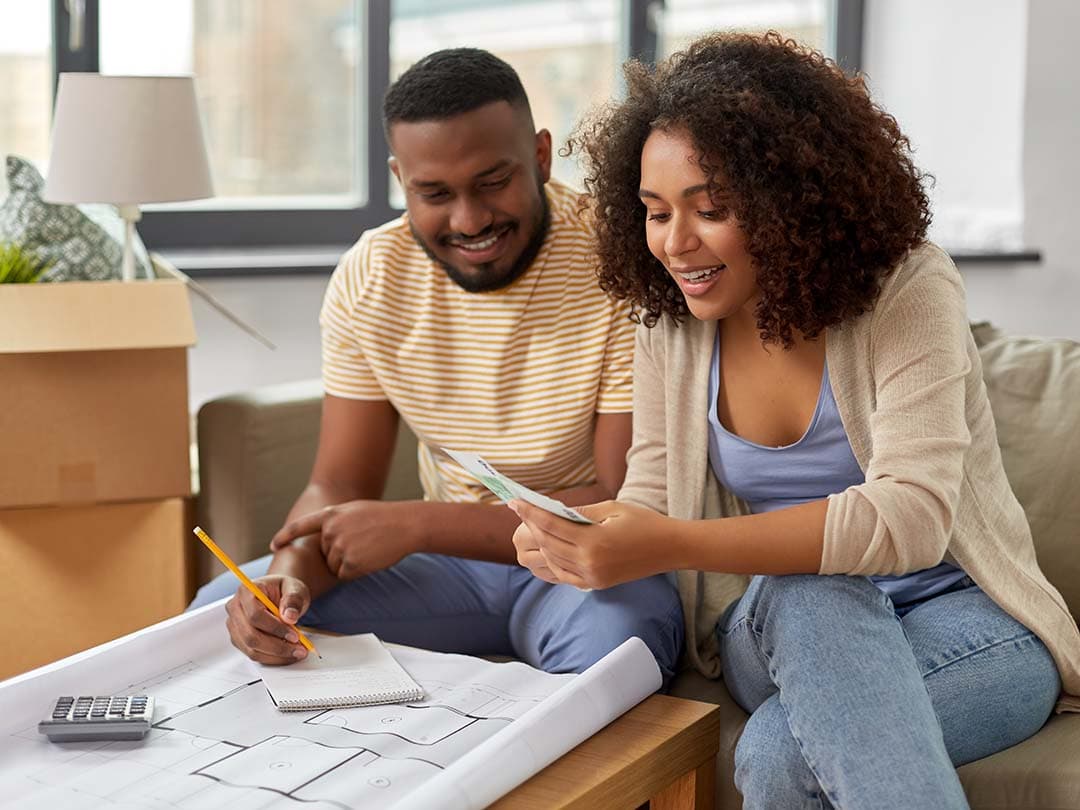 A couple sitting next to each other reading a piece of paper