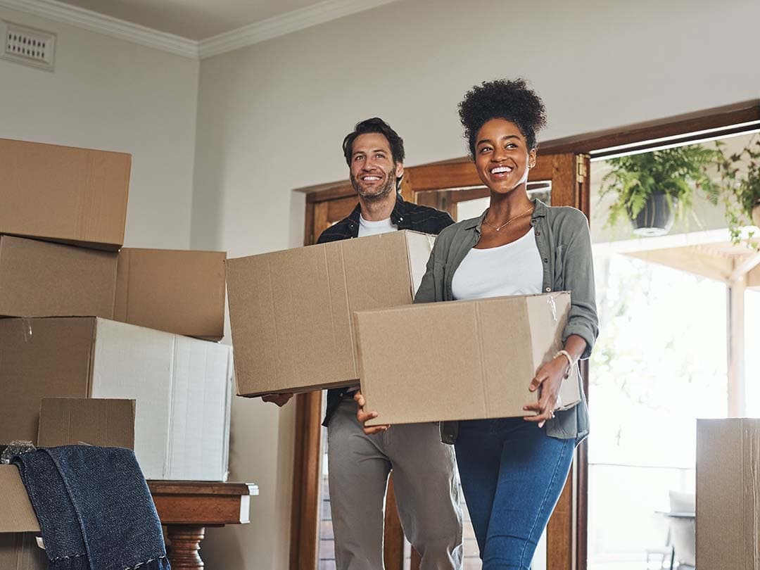 A man and woman holding moving boxes
