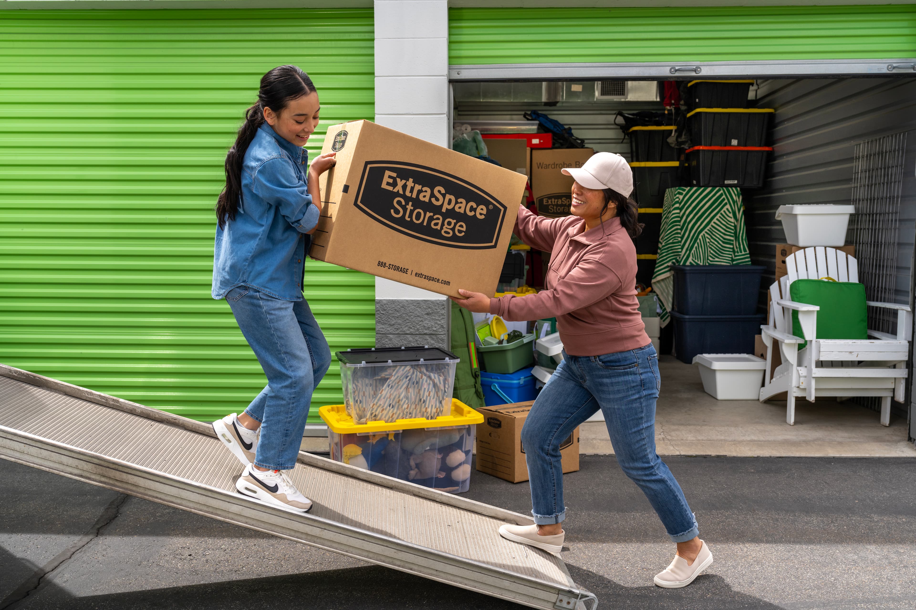 Happy Mother and Daughter Carrying Box into Extra Space Storage