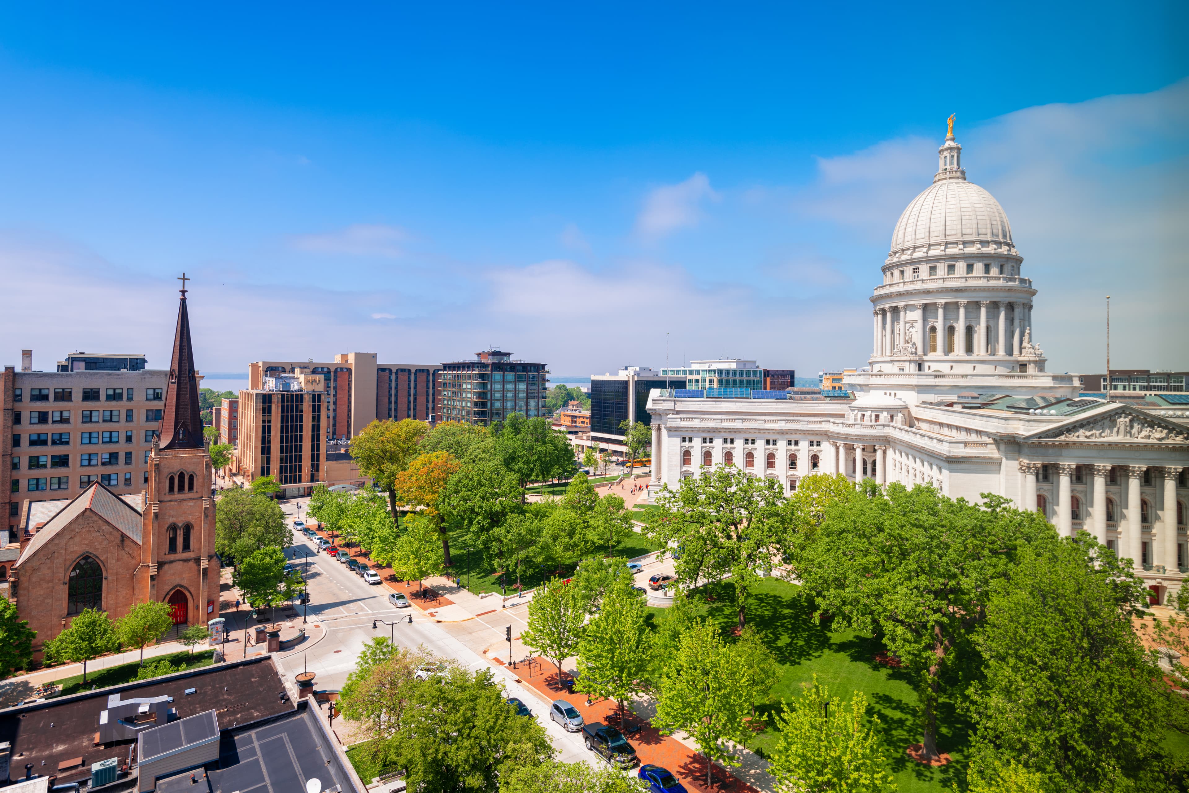 Aerial view of Downtown Madison, Wisconsin—featuring the State Capitol building, surrounding buildings, and tree-lined streets.