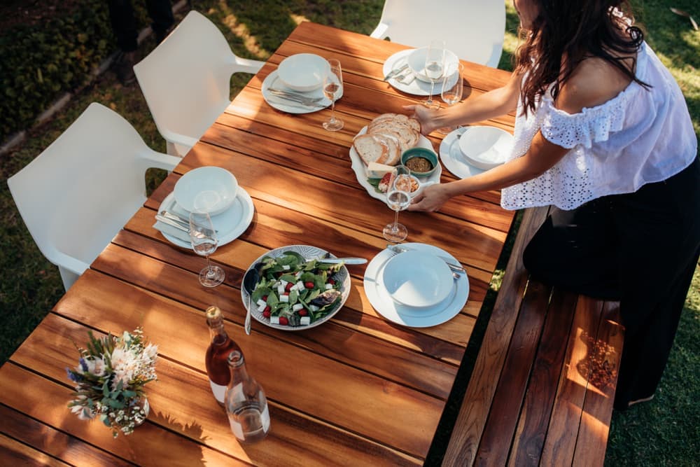 A woman setting the table outdoors for a meal