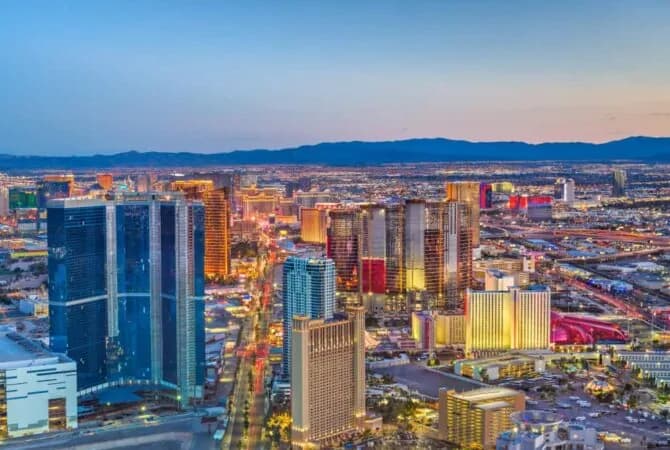 Las Vegas skyline at dusk with clear sky and buildings on and off the strip lit up
