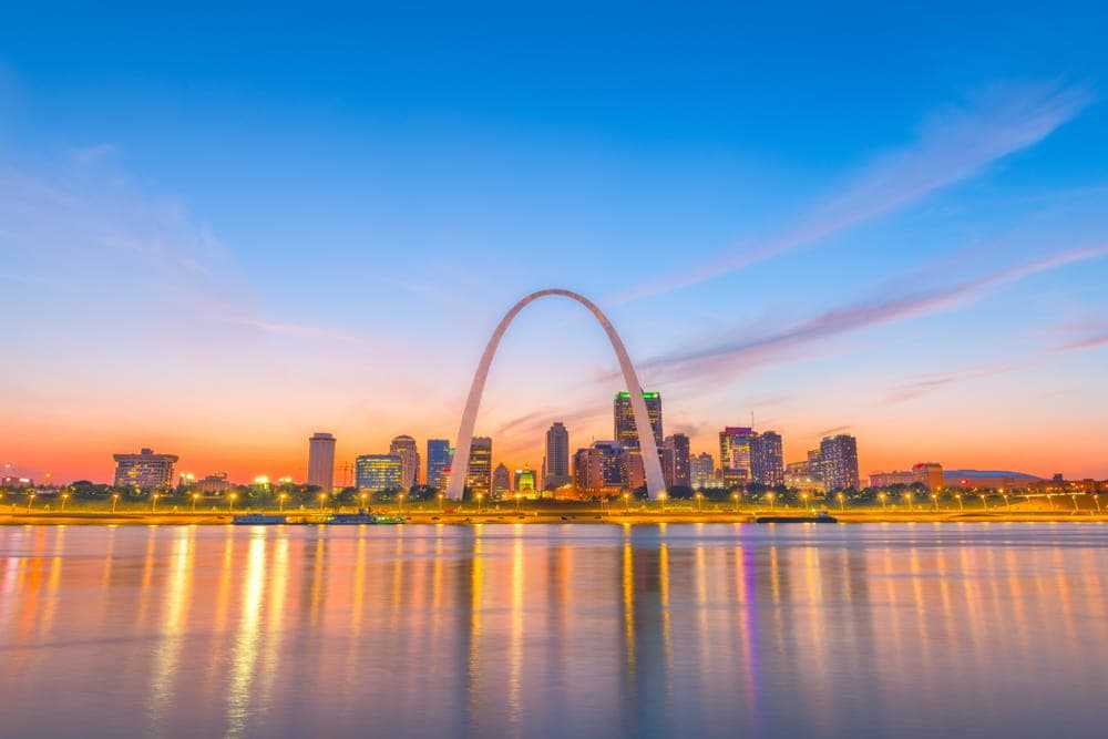 City view of St. Louis, MO & the arch close to water.