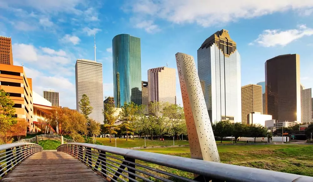 Houston, TX skyline on a bridge in Bayou Park with buildings and clear blue sky mid-day