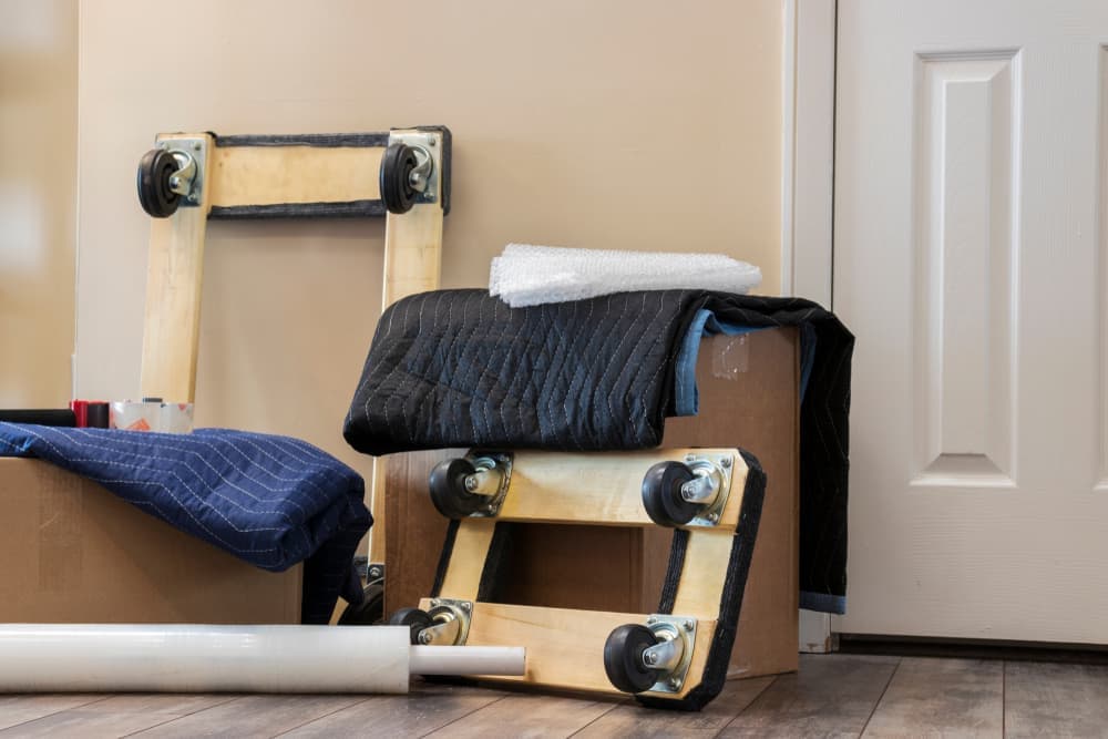 Moving supplies and boxes with moving blankets on it.