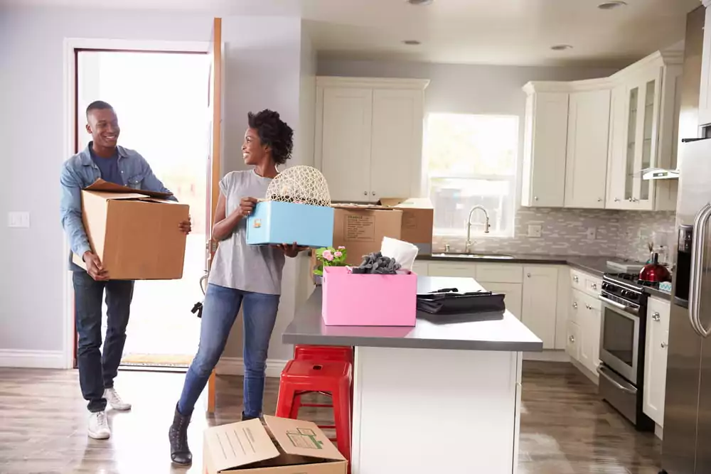 Two people holding moving boxes
