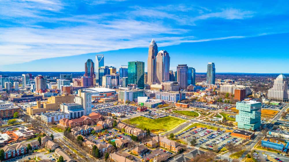 Charlotte, NC city skyline on a clear day, featuring high-rise buildings and urban landscape.