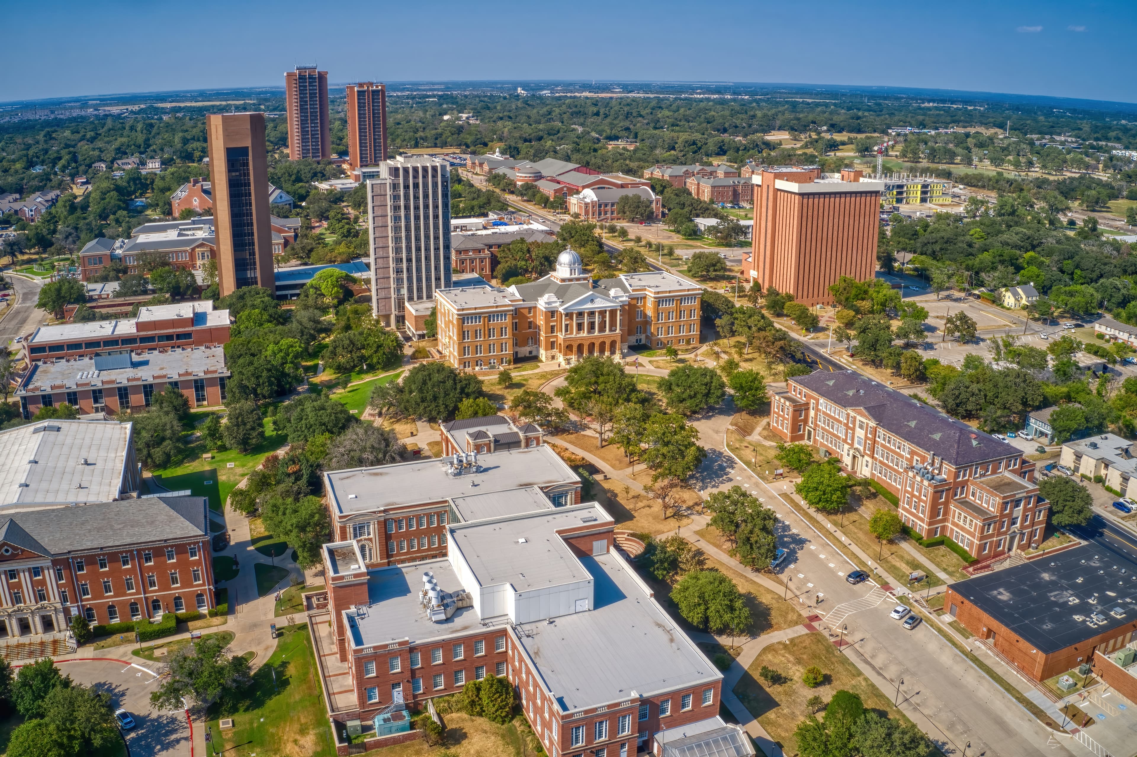 Aerial image of Denton, TX on a sunny day with blue, cloudless skies.