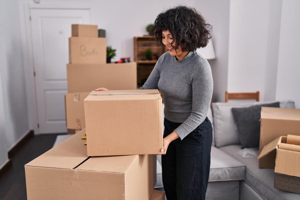 Woman holding a moving box in living room