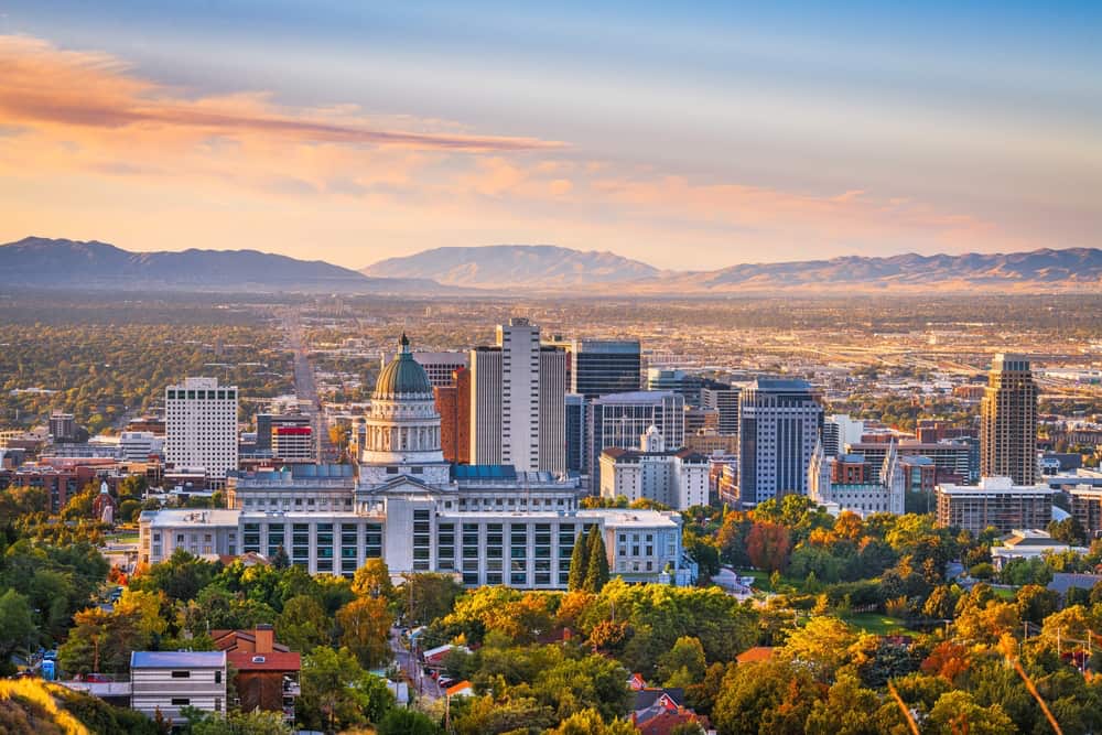 View of downtown Salt Lake City featuring the Utah State Capitol building, city skyline, and surrounding mountains