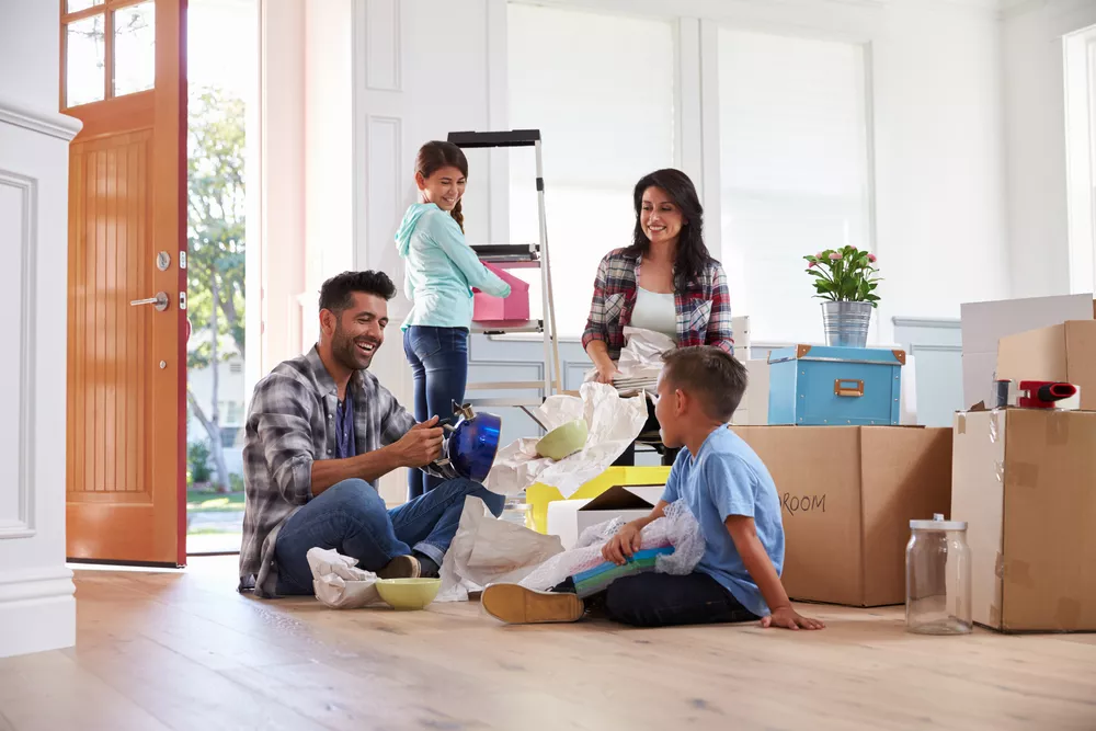Young family packing up household items for move while sitting in living room