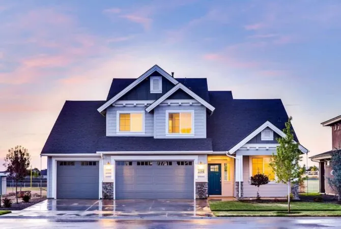 A professional photo of a house at dusk with the lights on