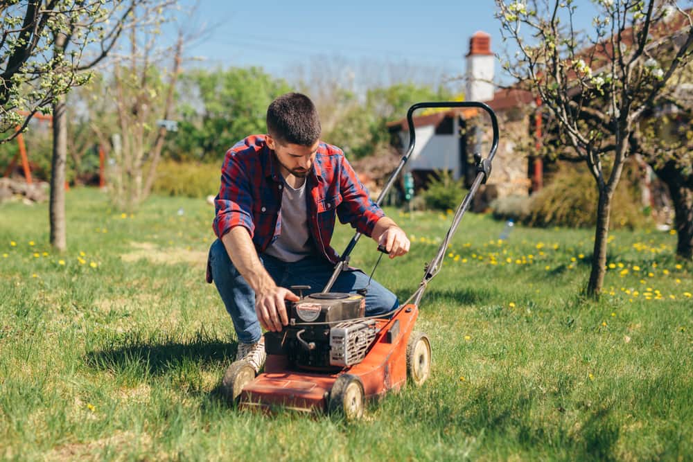 Man inspecting a lawn mower