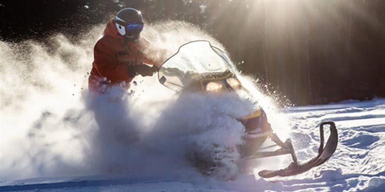 person riding snowmobile through snow