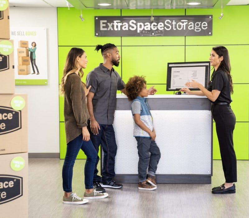 Family of three speaking with an Extra Space Storage employee