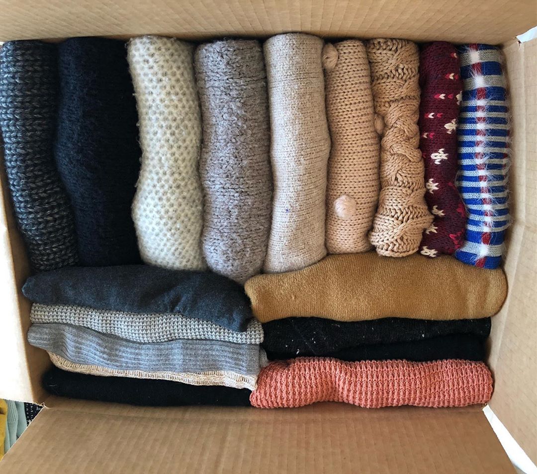 Sweaters neatly folded in large moving box. Photo by Instagram user @chaos.organizer