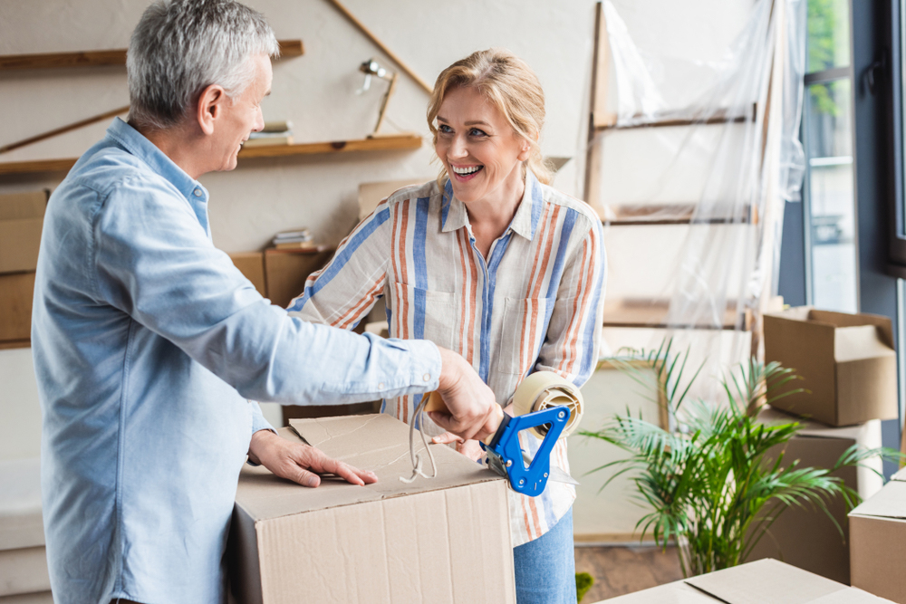 Older couple packs a moving box together