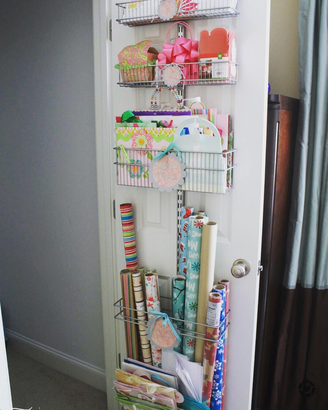 Door storage with wrapping paper and gift supplies. Photo by Instagram user @turquoisehome