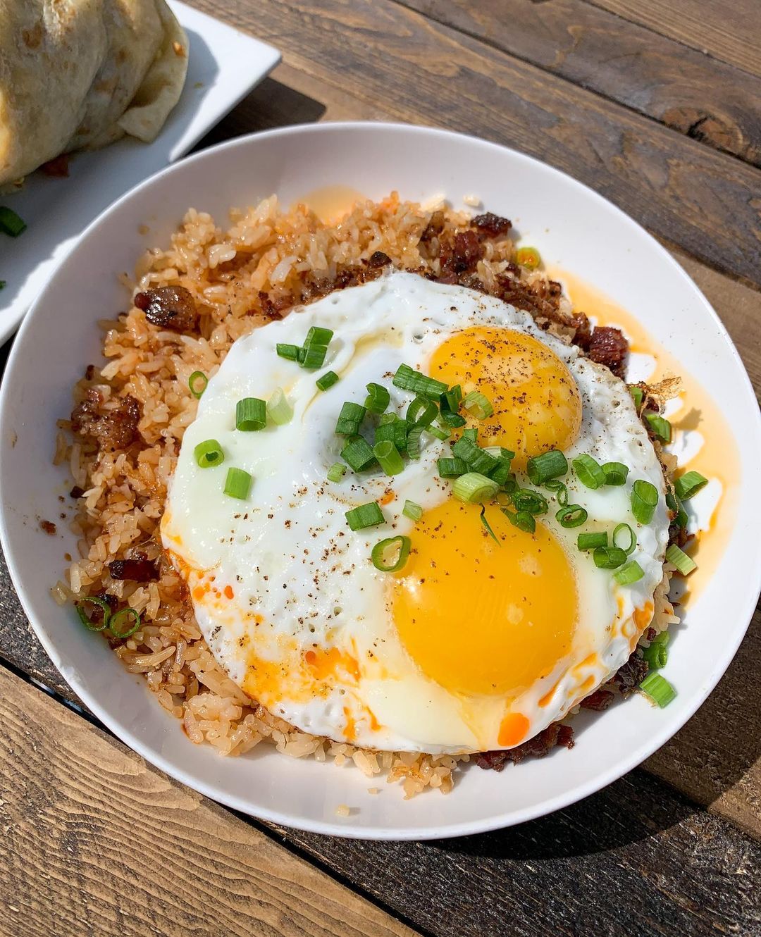 Plate of Bacon Fried Rice with Two Eggs on Top from OneFold in Denver. Photo by Instagram user @logansbitesandsights