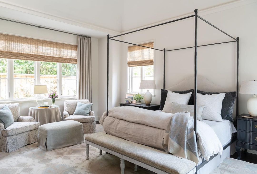 Neutral toned bedroom with sitting area, open windows, and natural lightning. Photo by Instagram user @gingerbarber.interiordesign