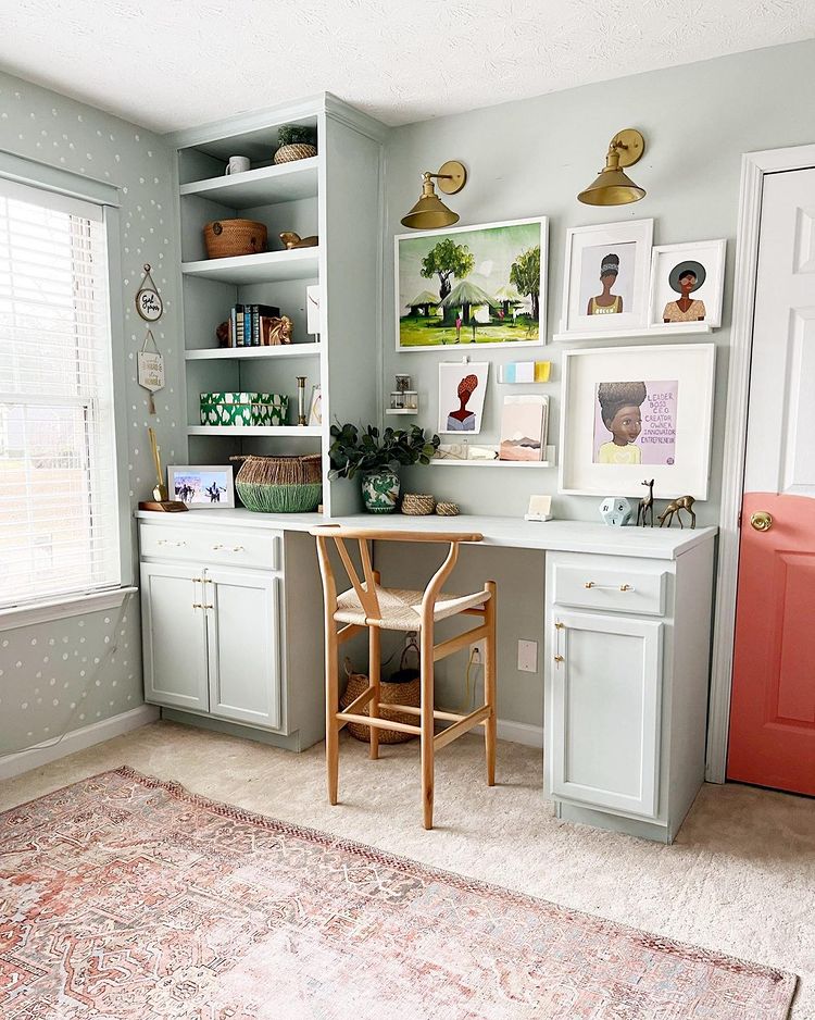 In-home offic with a built-in desk and cabinet set, light gray walls, and neutral carpeting. Photo by Instagram user @liveprettyonapenny