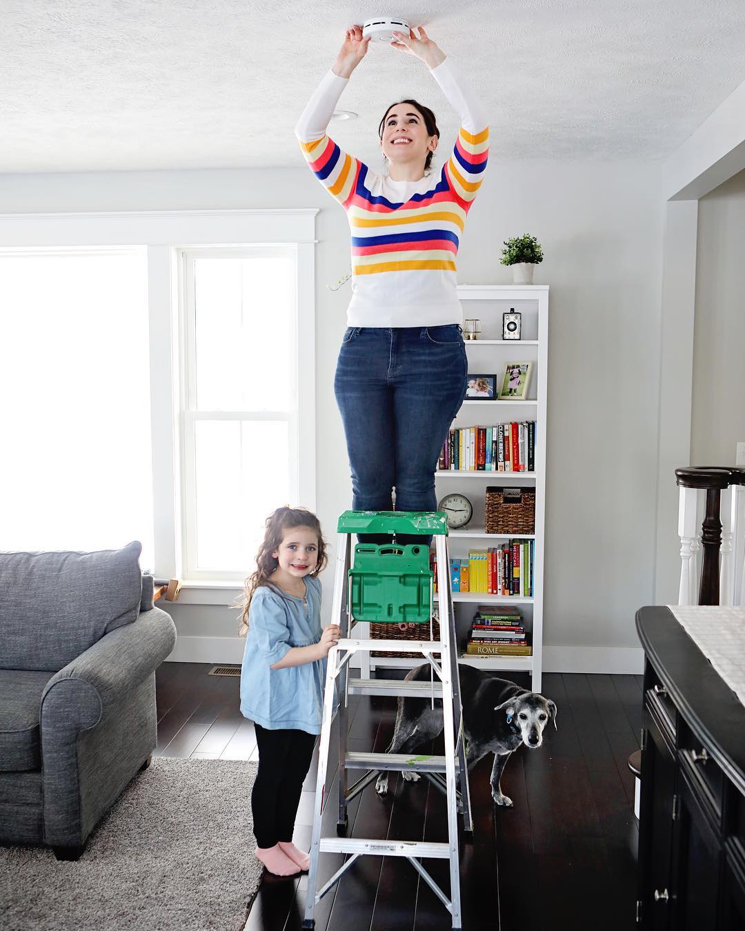 Woman changing smoke detector in home. Photo by Instagram user @rachelquenzer