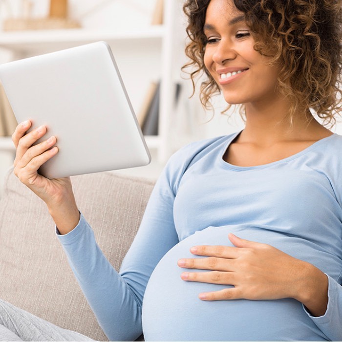 A pregnant mother doing research on a tablet. Photo by Instagram user @apexbenefitgroup.