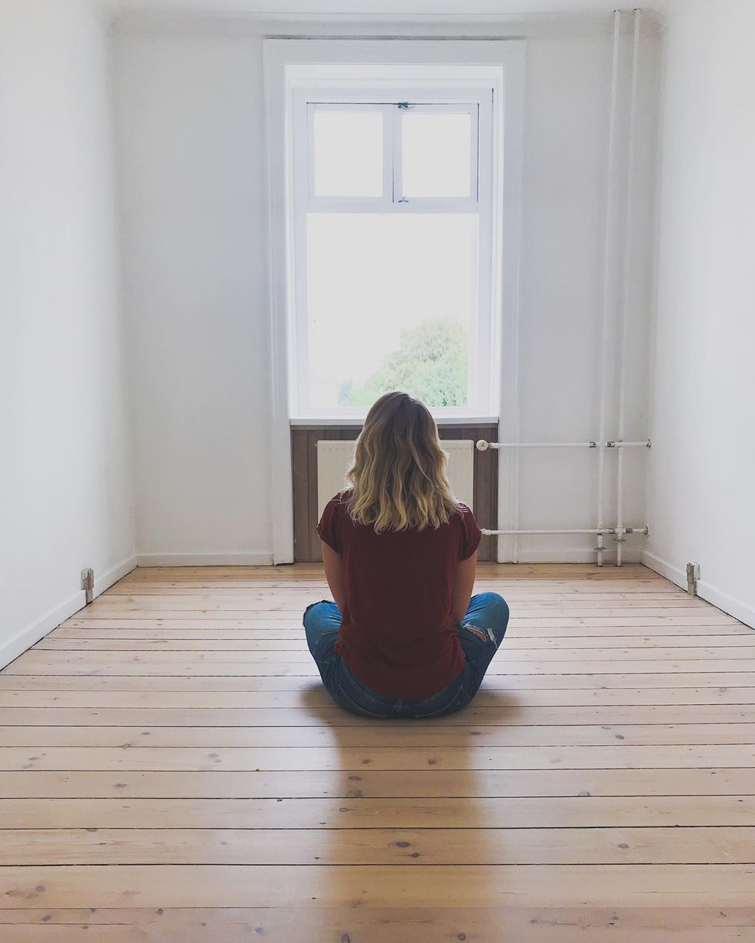 Woman sitting in an empty room. Photo by Instagram user @carosauar