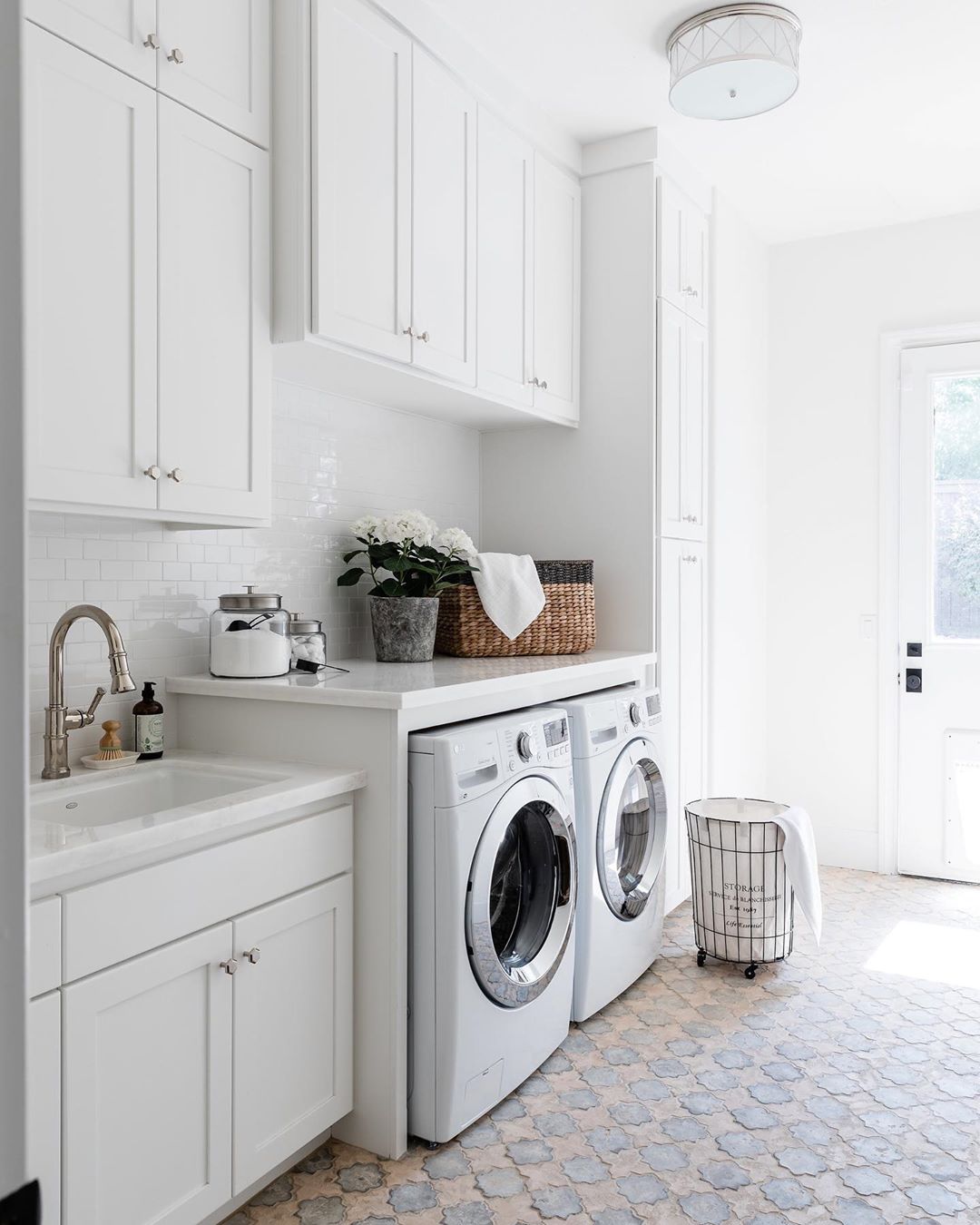 White laundry room with natural light. Photo by Instagram user @katrina_stumbos