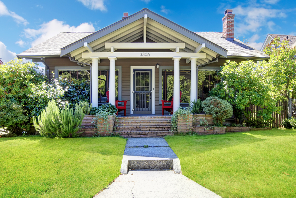 A small house facade with a green lawn