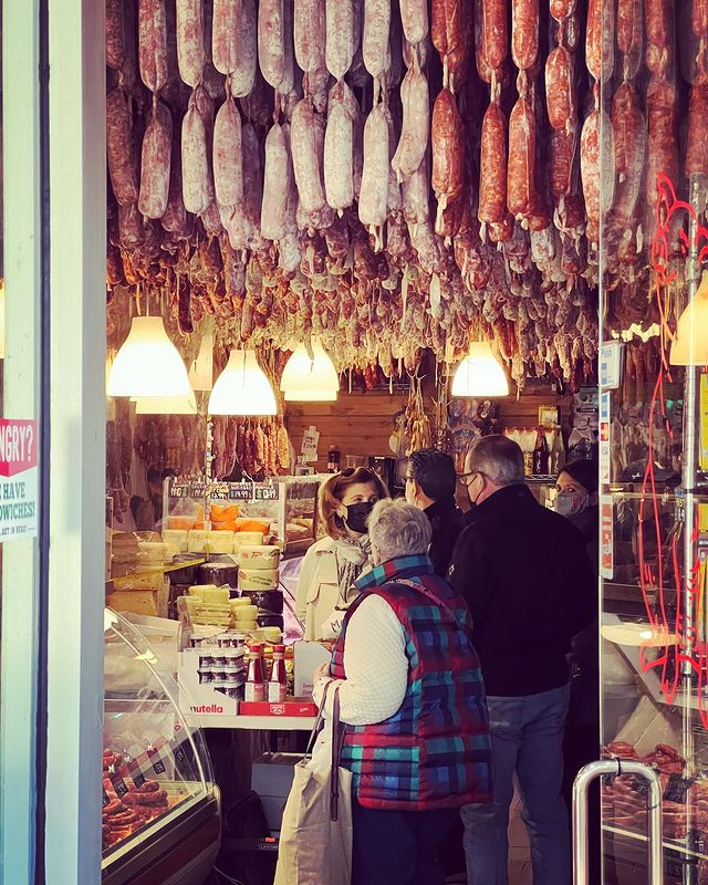 Customers in a hanging salami shop. Photo by Instagram user @erickschonfeld