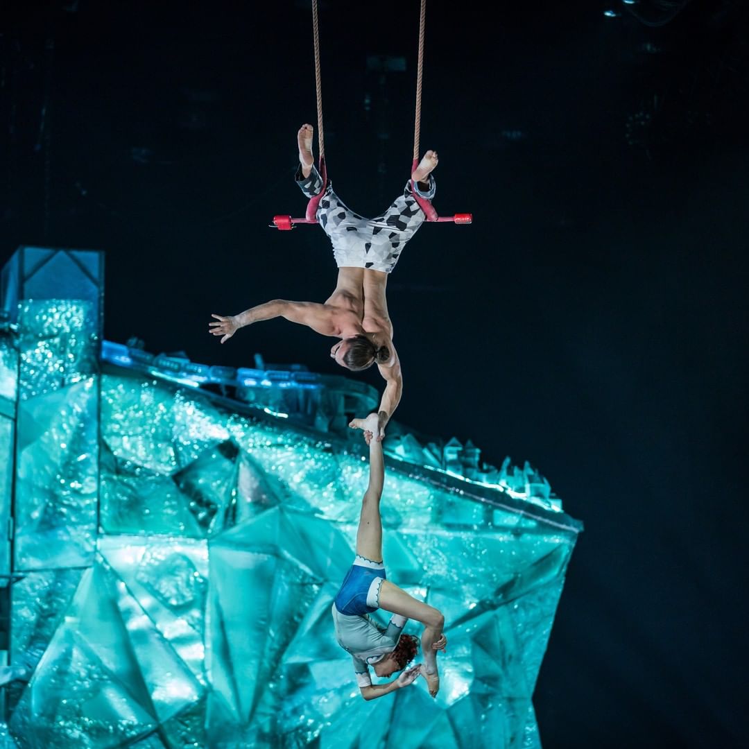 Acrobatic performers in the air at a Cirque du Soleil show. Photo by @cirquedusoleil
