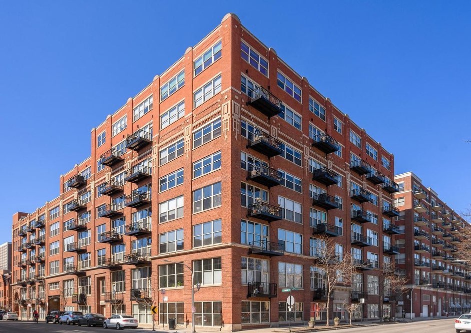 Brick apartment complex with balconies at mid-day. Photo by Instagram user @mvpchicagorealestate