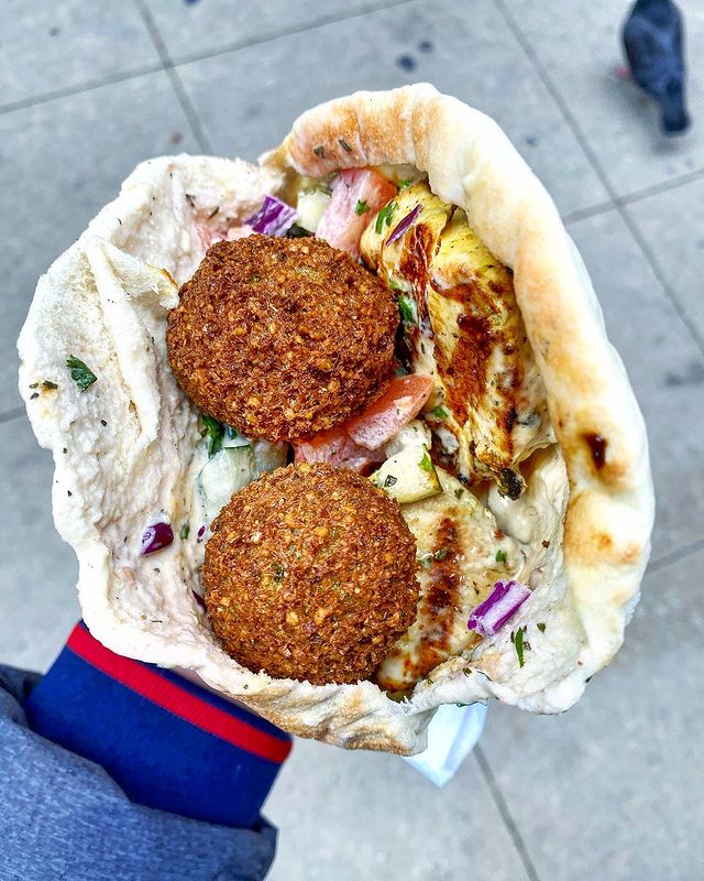Person Holding a Falafel Wrap from Oasis Cafe in Chicago. Photo by Instagram user @bestfoodalex