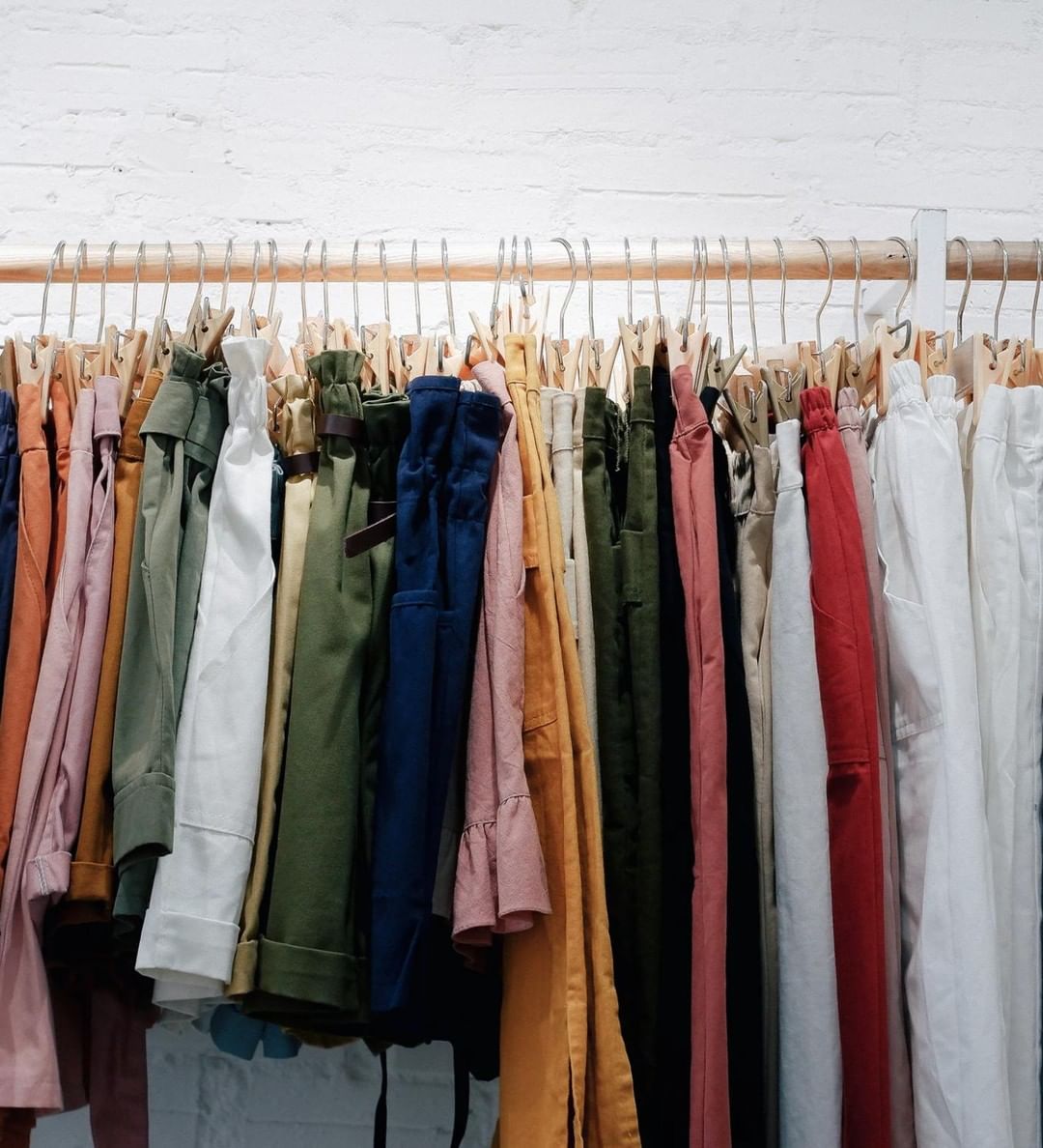 Women's Shorts, Pants, and Jackets on a Hanging Rack in a Store. Photo by Instagram user @goodwillnynj
