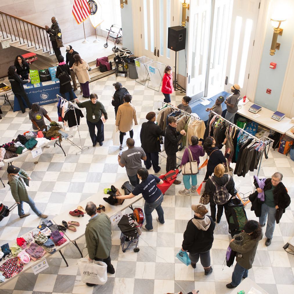 People Looking Through Tables Full of Donated Clothing. Photo by Instagram user @grownyc