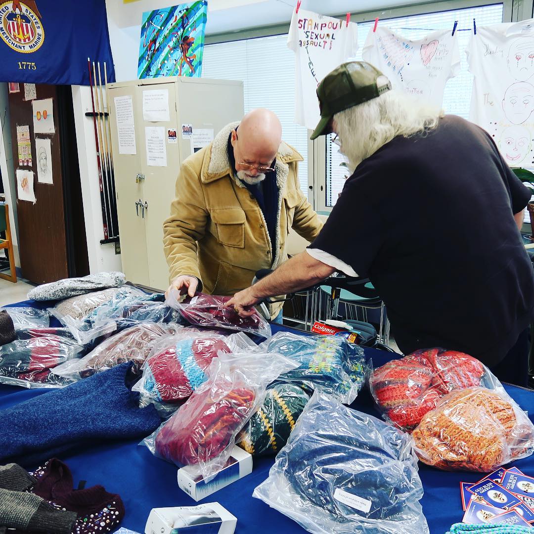 Men Looking Through Bags on Donated Clothes on Tables. Photo by Instagram user @uwvc