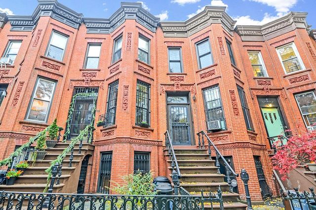 View of New York City brownstones and their wrought-iron steps. Photo by Instagram user @ brownstonepropertygroup