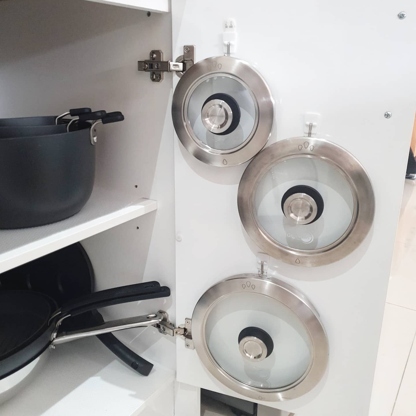 Three pot lids mounted on a kitchen cabinet drawer. Photo by Instagram user @keepingupwiththewillows