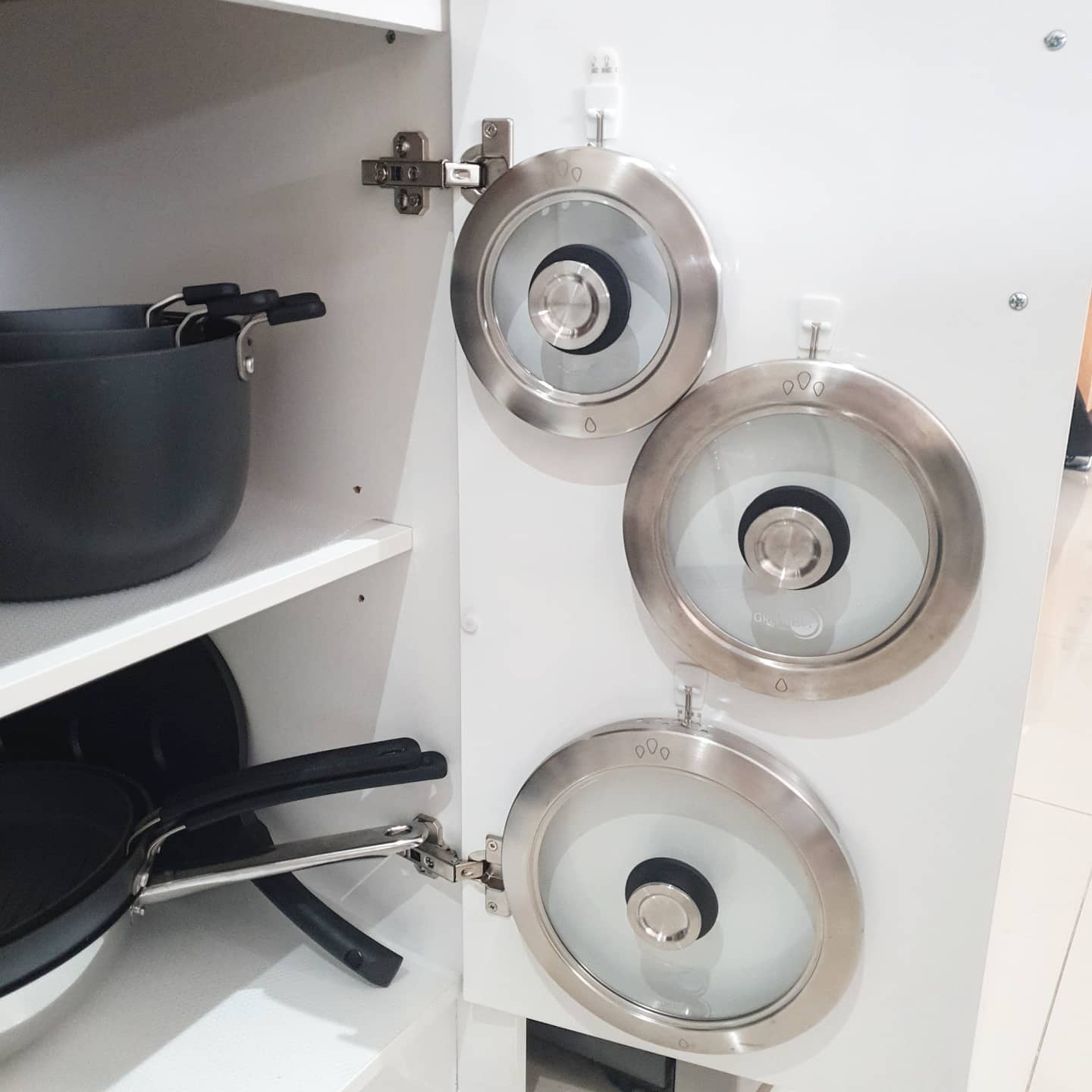 https://www.extraspace.com/blog/wp-content/uploads/2017/01/how-to-declutter-kitchen-organize-lids-on-cabinet-doors.jpeg