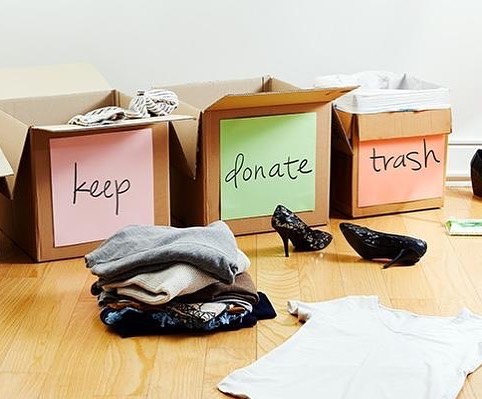 Boxes labeled keep, donate, and trash filled with clothes. Photo by Instagram user @chiropractic_family_wellness