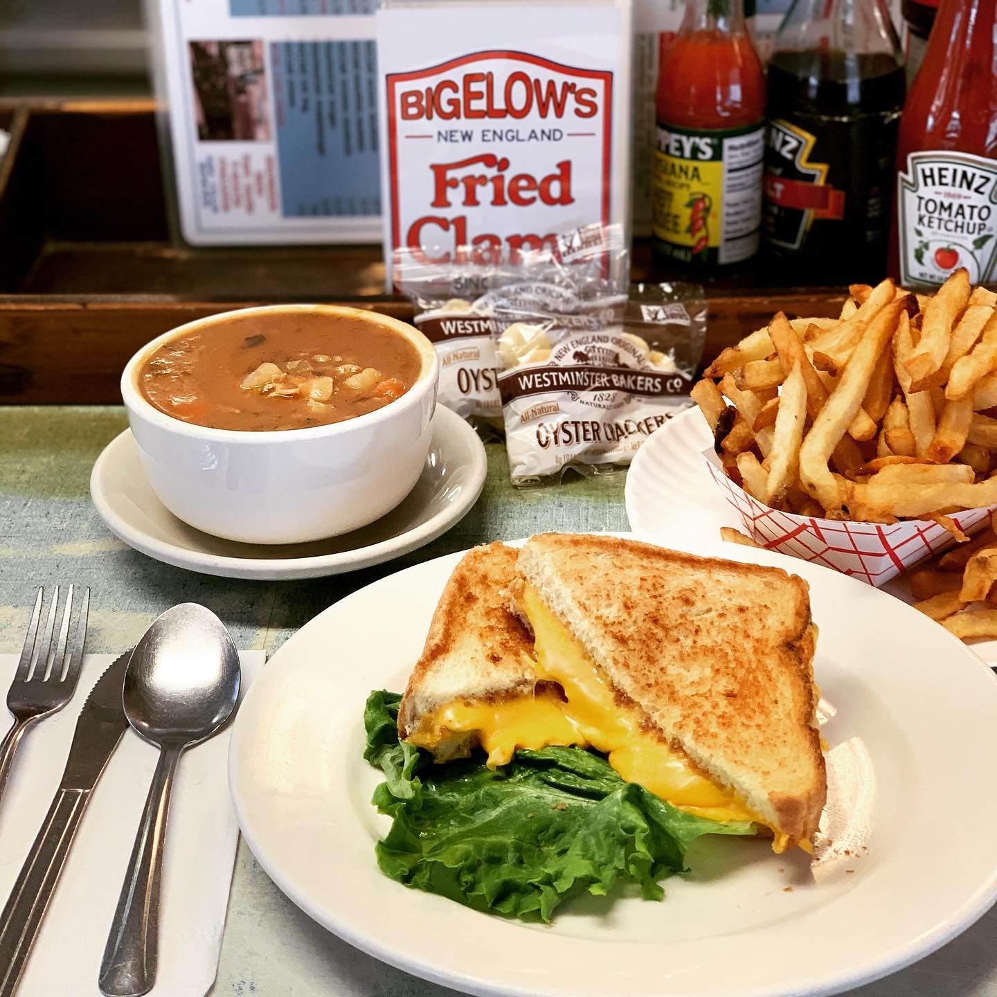 Bowl of clam chowder, grilled cheese sandwich, and basket of fries. Photo by Instagram user @bigelowsfriedclams