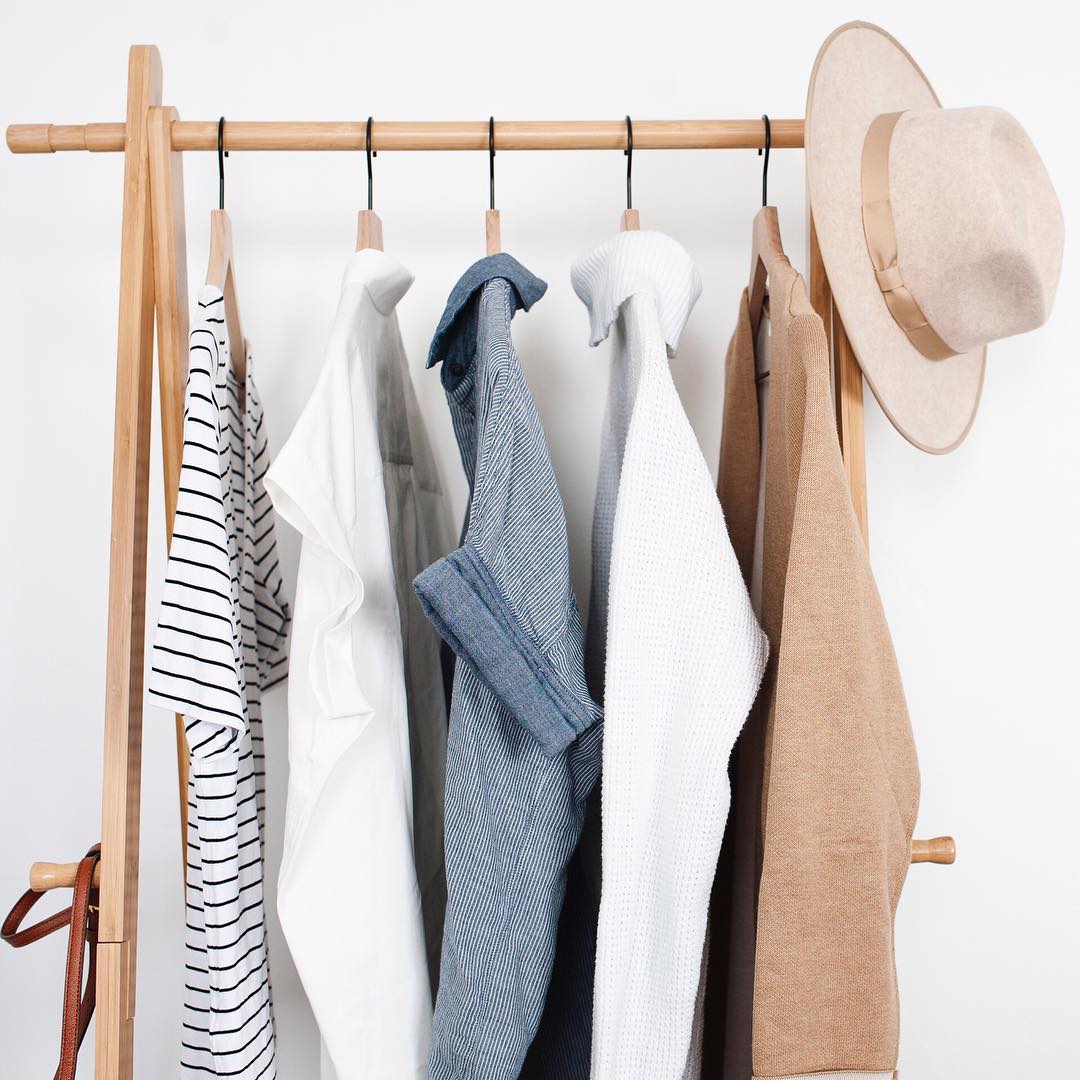 Five shirts and hat hanging on rolling clothing rack. Photo by Instagram user @incrediblyorganized