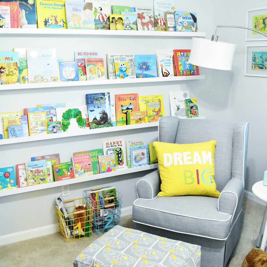 Nursery room with wall of books. Photo by Instagram user @lovinghereblog