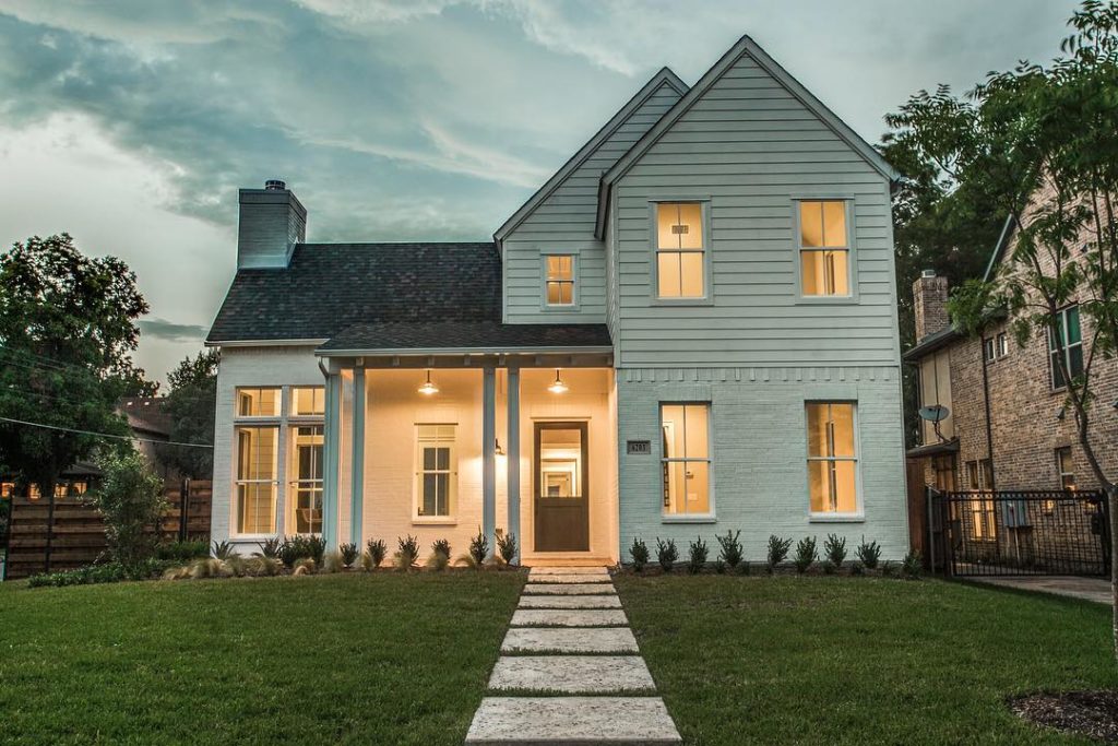 white panel house with green yard during sunset in Lakewood Photo via @kylepbrinkley