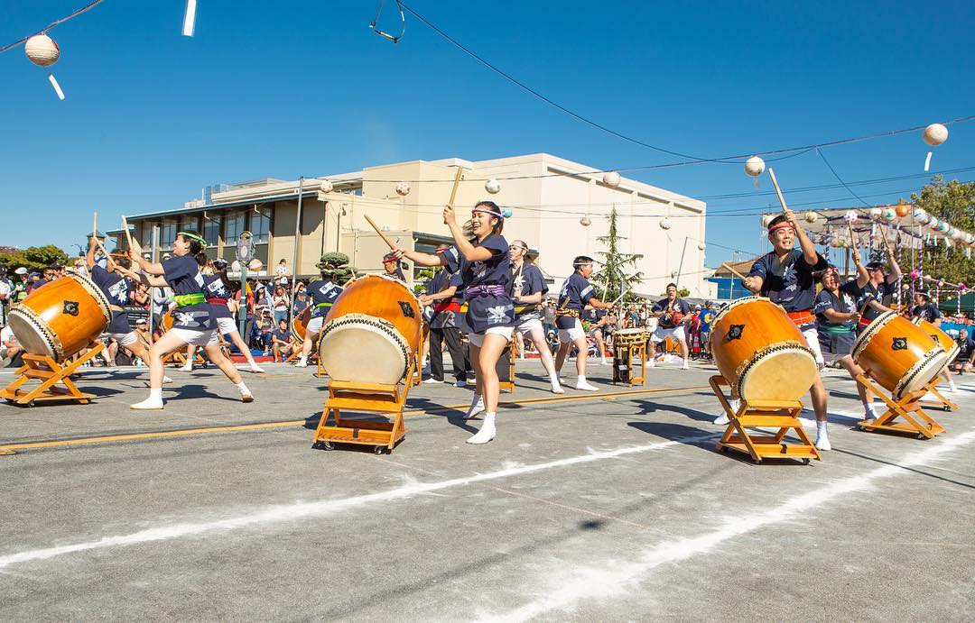 Teens playing drums on the street during an outdoor performance with people watching in background. Photo by Instagram user @sanjosetaiko